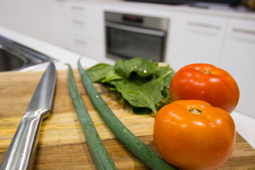 Chopping Board On A Kitchen Bench Full Of Fresh Healthy Vegetables And A Oven In The Background