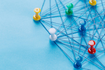 Small network of colorful pins and string, An arrangement of colorful pins linked together with...