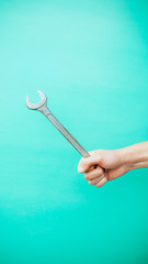 wrench in hands, on a blue background