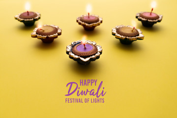 Happy Diwali - Clay Diya lamps lit during Dipavali, Hindu festival of lights celebration. Colorful...