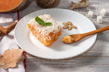 Slice of fresh homemade pumpkin pie and semolina on a white plate on a light background. . A Thanksgiving or holiday treat. Traditional autumn dish