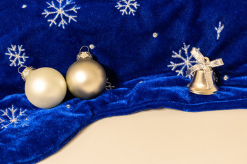 Festlicher Weihnachtsschmuck auf blauem Samt mit Schneekristallen, Weihnachtskugeln und copy space verschönert die Vorfreude auf die Weihnachtszeit im Advent