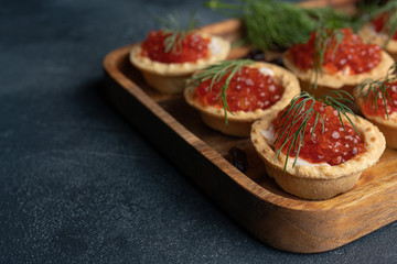 Red caviar in tartalets on a stone table