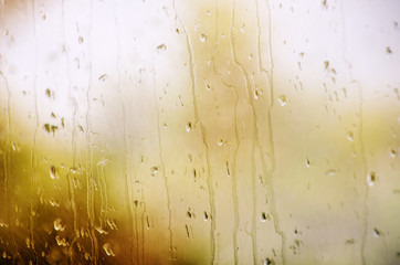 Autumn glass window with raindrops, background