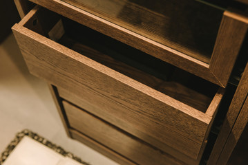 Wooden cupboard with opened empty drawer.