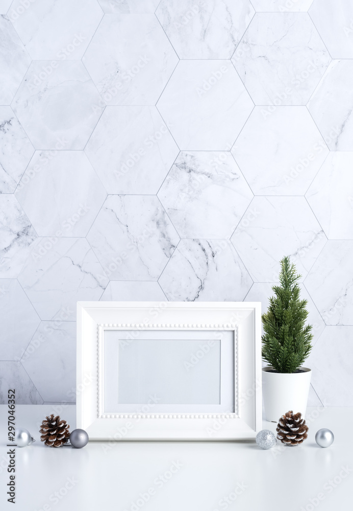 Poster white vintage photo frame with christmas tree,pine cone and decor xmas ball on white table and marbl