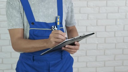 Write an estimate. The builder writes an estimate on a tablet.