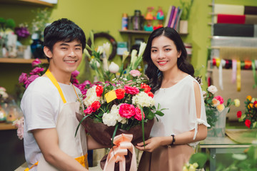 Male florist offering flowers at the counter in the florist shop