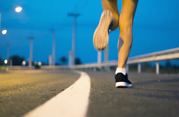 Movement. Woman legs running on asphalt road.