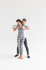 Young couple dancing latin dance bachata, merengue, salsa, kizomba. Two elegance pose over white background with copy space