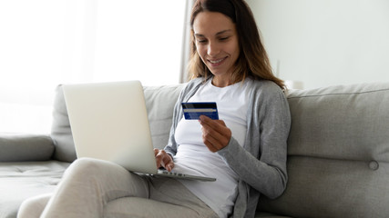 Smiling millennial mixed race woman making purchases online.