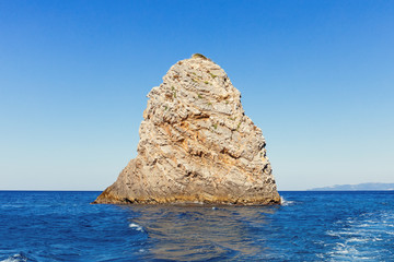 Fototapeta na wymiar Single rock with clear blue sea water