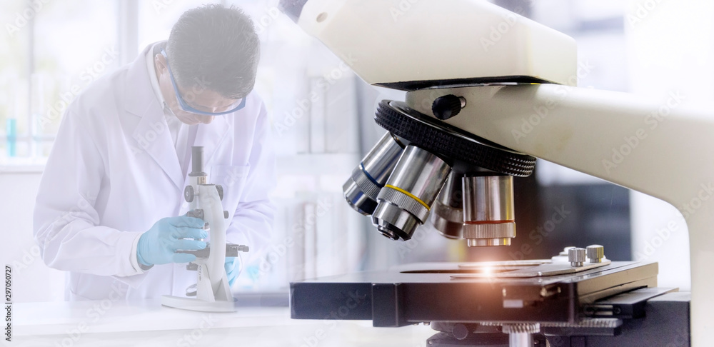 Wall mural laboratory concept: close up picture of microscope with blurred background of scientist researching 