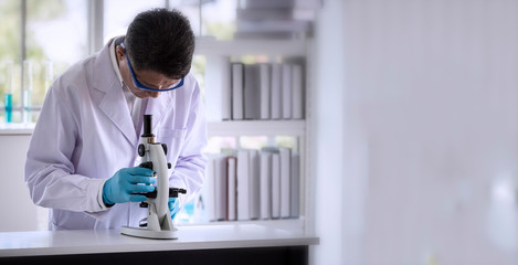 Laboratory concept: Scientist researching by microscopy technique in laboratory with copy space.