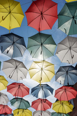 Fototapeta na wymiar Colorful umbrellas in the sunshine. Rue du Cul-de-Sac, in the Quartier Petit Champlain, in Quebec City