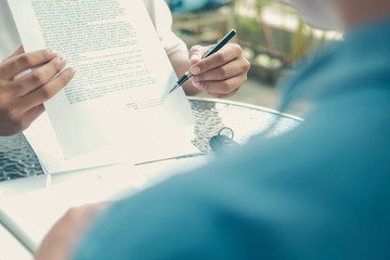agent shows car insurance to lender. salesman dealer presenting purchase order contract to customer.