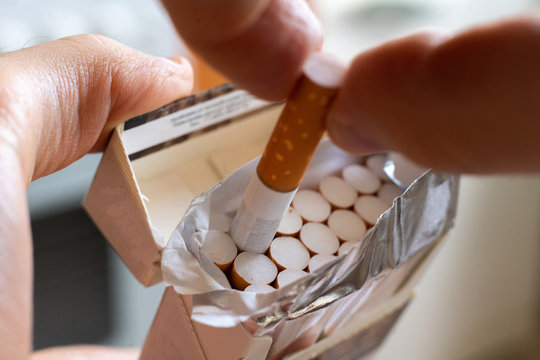 Close Up Person's Hand Pick A Cigarette From The Carton Pack Box