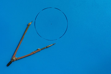 top view of the pair of compasses on the surface to make a sketch with circle