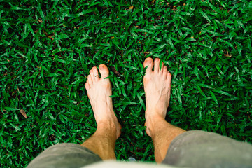 male's feet on green grass