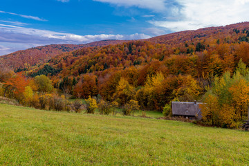 House in Mountains covered with forest in the autumn season