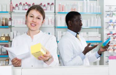 Obraz premium Female pharmaceutist showing medicines in pharmacy