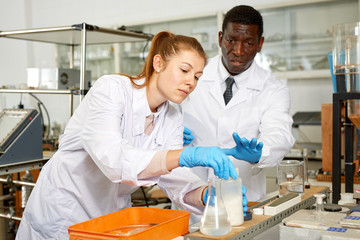 Focused lab technician woman with tubes and worried man  technician