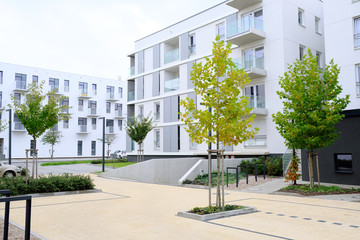 Sidewalk in a cozy courtyard of modern apartment buildings condo with white walls. - obrazy, fototapety, plakaty