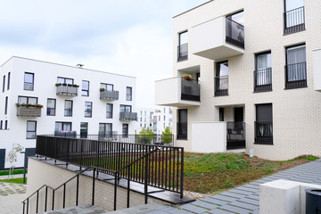 Cozy courtyard of modern apartment buildings district with white walls.