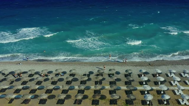 Tropical beach video loop showing seamless never ending footage with aerial bird eye view of green foaming ocean waves crushing against the coast line of Florida and overhead view of a seldom tourist