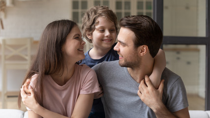 Little son hugging happy mother and father, enjoying tender moment