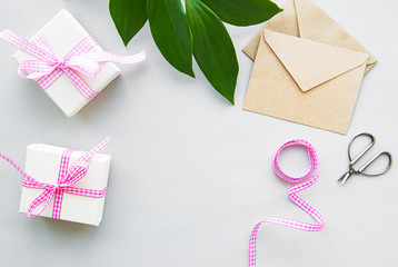 Gift boxes, envelope and with green leaves on a white background