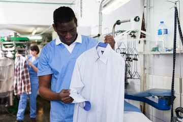Man worker checking quality of cleaning clothes