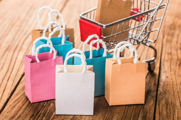 Colorful paper shopping bags in a trolley. Ideas about online shopping addiction.