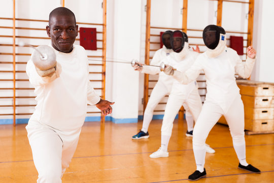Sporty african american man fencer practicing effective fencing techniques - Powered by Adobe