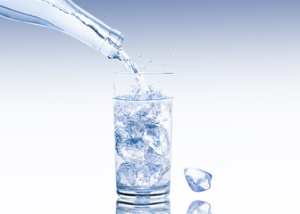 Ein Glas  mit Eiswürfeln wird mit frischem Wasser gefüllt