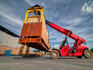 Reachstacker handling full loaded container for export in yard .
