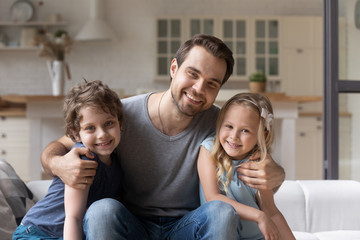 Portrait smiling father with adorable son and daughter at home