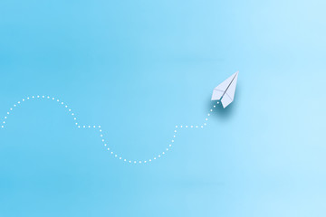 Leadership concept with red paper plane leading among white on blue background