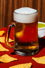 A pint of beer, tortilla chips and guacamole. Pop colorful contemporary style