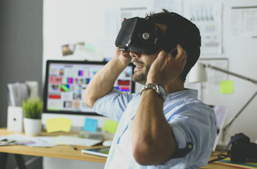 Young male software programmer testing a new app with 3d virtual reality glasses in office.