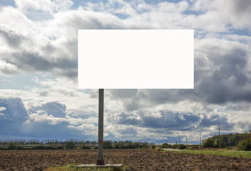 Billboard with empty place for writing text on field and sky background.