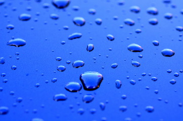Wassertropfen auf blauem Lack