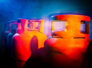 Gas bottels illuminated with smoke and light in different colors, blue and orange , captured in a studio