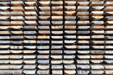 The ends of roughly trimmed boards a stack of lumber