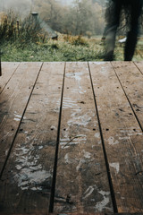 low angle close up of wooden floor in a country side with a man walking away