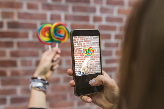 Taking a picture of a lollipop against a brick wall