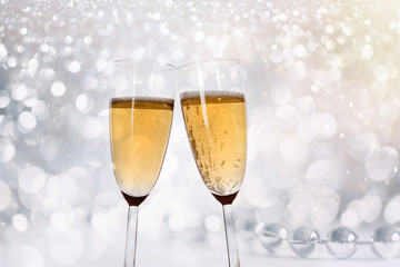 New Years eve concept with bokeh, fireworks and glasses of champagne.
