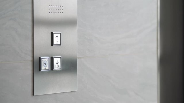 Female Hand Pushing Elevator Button in Office Center or Hotel. Young Woman Pressing Lift Button Up. 4K Slowmotion.