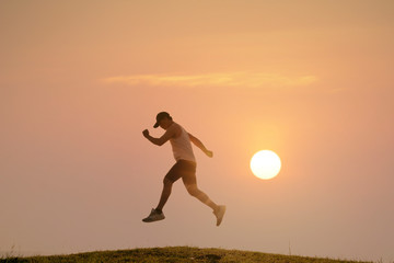 runner on rural track with sunset or sunrise, sport and healthy concept