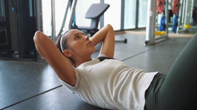 Young Girl Doing Hard Abs Workout Exercises in the Gym. 4K Slowmotion.